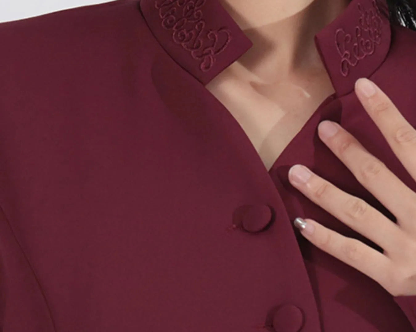 NEWYORKLISTED STYLE COLLECTION: Close-up of a burgundy coat with intricate detailing on the collar.