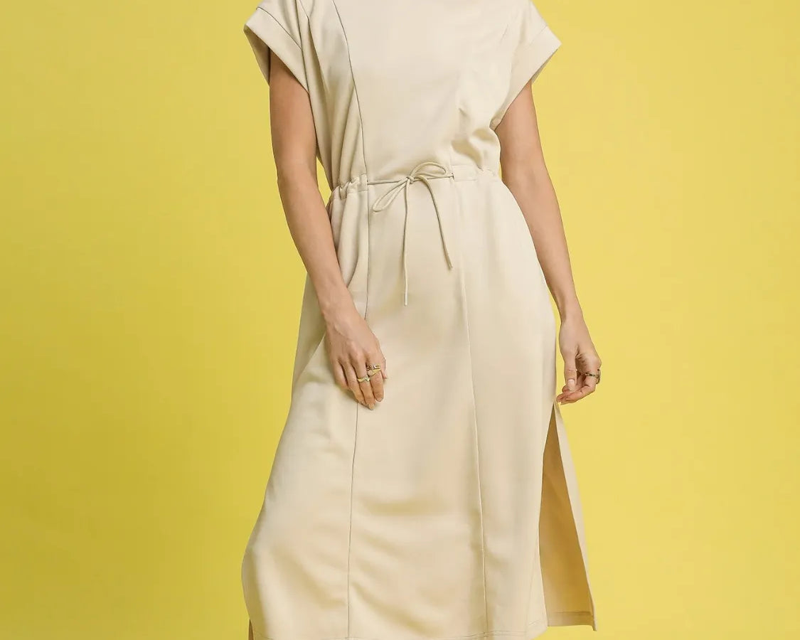 NEWYORKLISTED STYLE COLLECTION: Short Sleeve Midi Tee Dress Woman wearing a beige dress on a yellow background