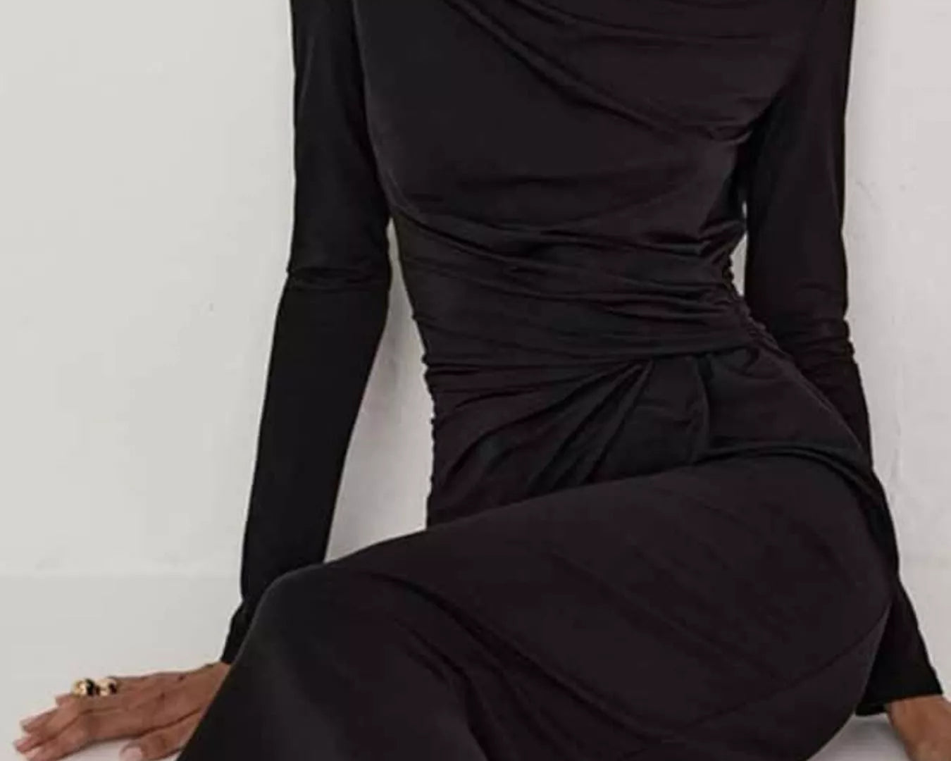 NEWYORKLISTED STYLE COLLECTION: Model is wearing a black long-sleeve dress against a white background