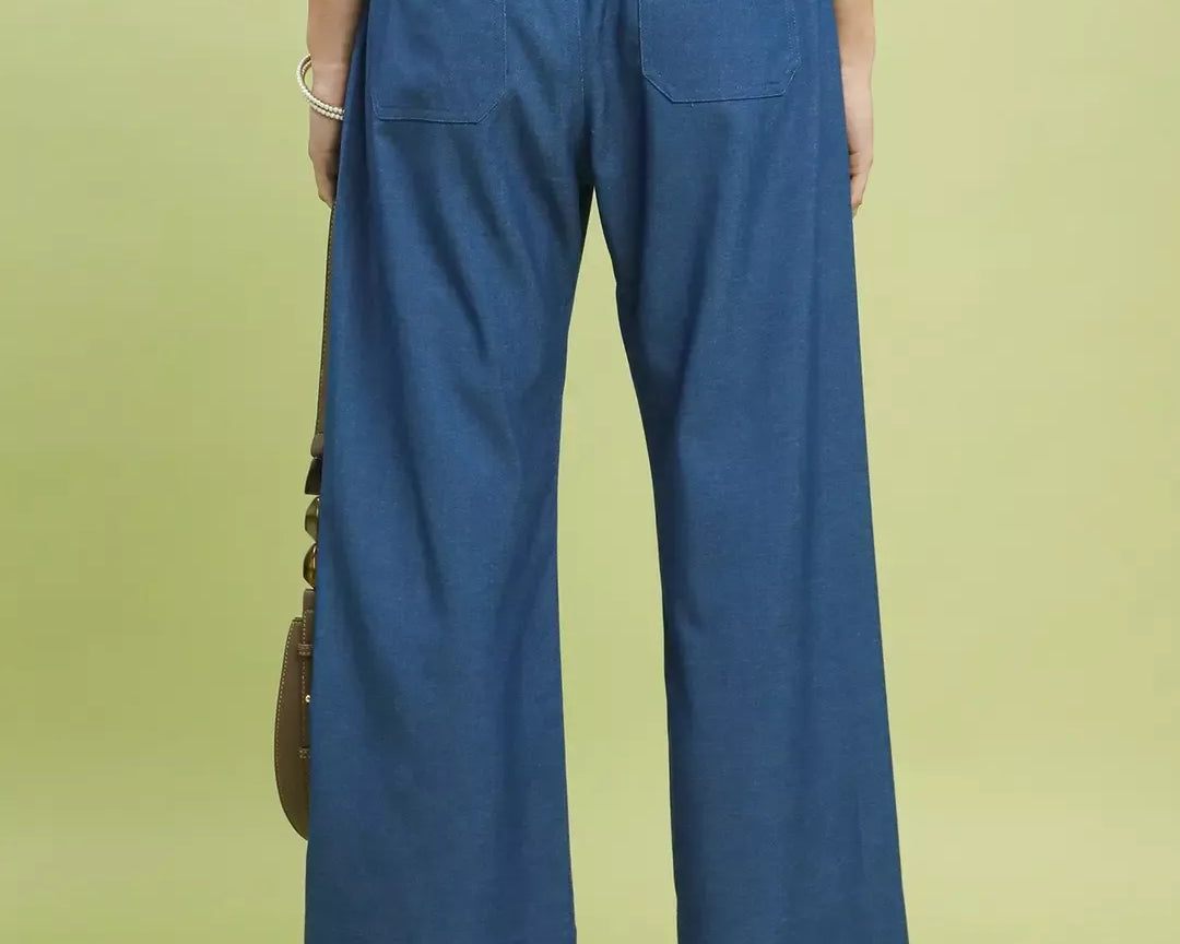 NEWYORKLISTED Style Collection: Person wearing blue denim pants on a light green background