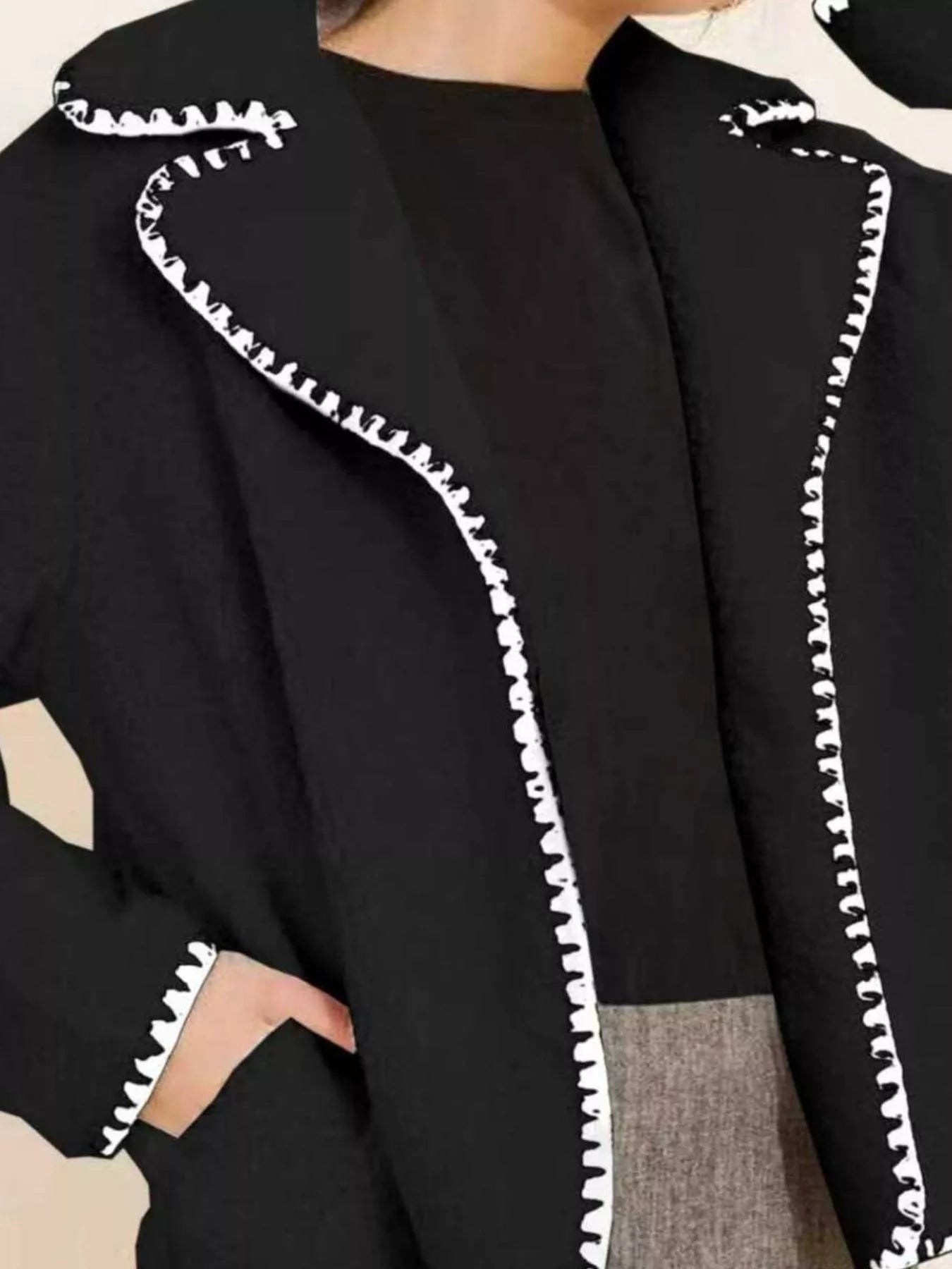 NEWYORKLISTED STYLE COLLECTION: Black garment with white trim on a neutral background