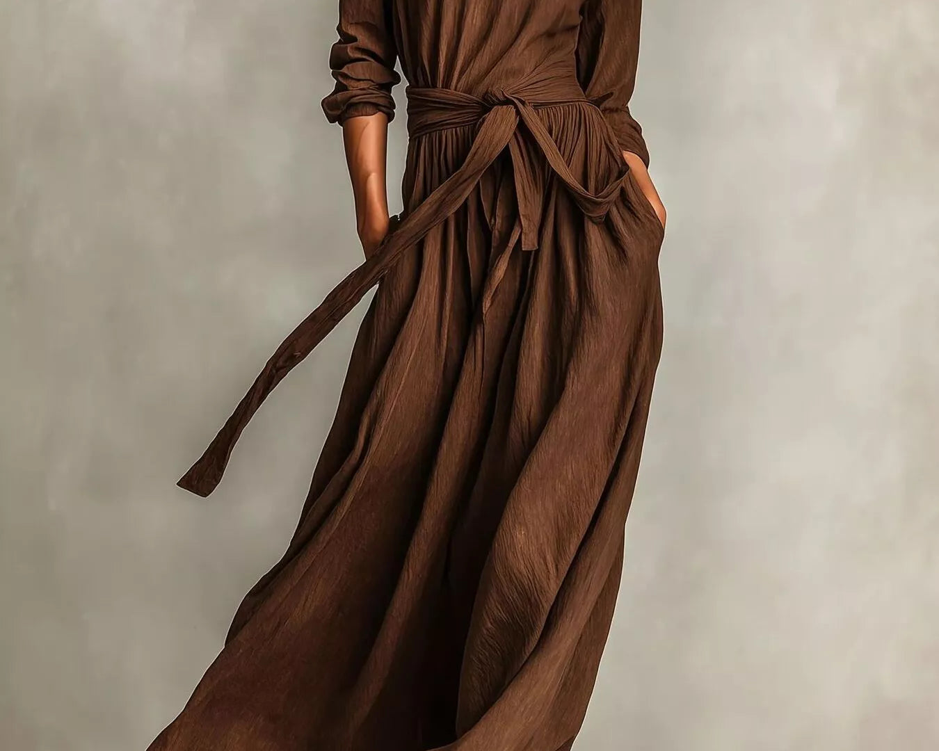 NEWYORKLISTED STYLE COLLECTION: Woman wearing a long brown dress against a neutral background