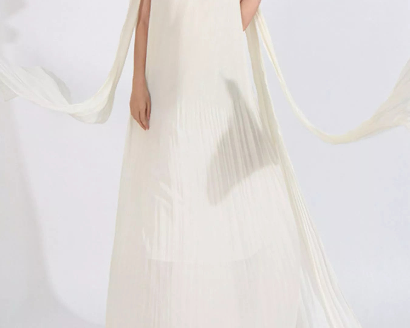 NEWYORKLISTED STYLE COLLECTION: Woman wearing a white strapless dress with floral details on a white background