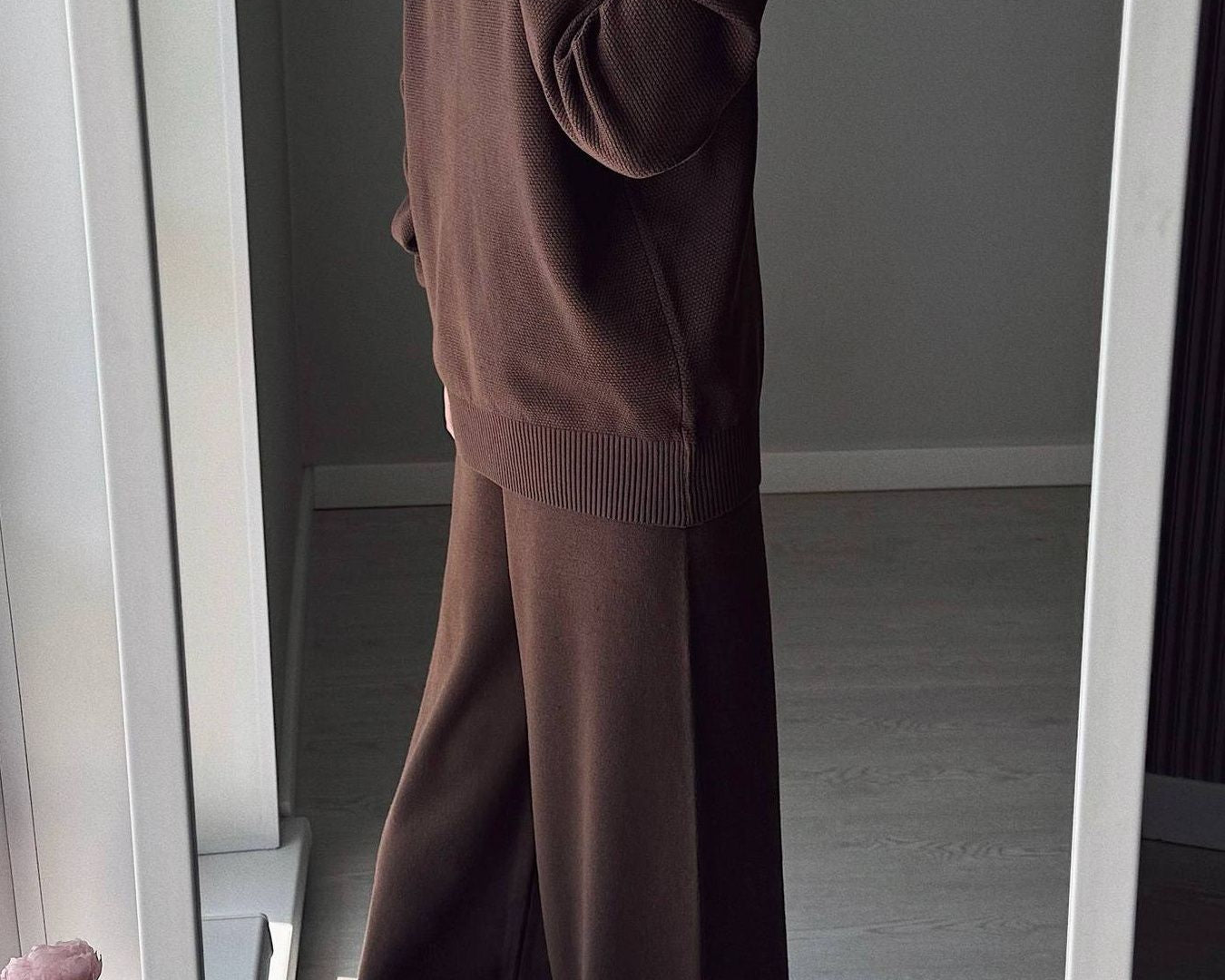 NEWYORKLISTED Comfort Collection: Person wearing a brown outfit taking a mirror selfie in a room.
