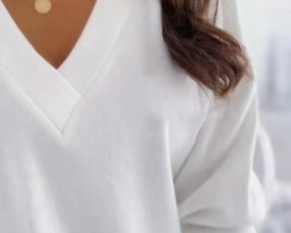 NEWYORKLISTED STYLE COLLECTION: White long-sleeve top worn by a person with gold necklaces.
