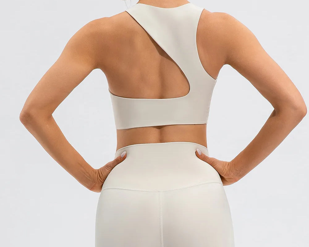 NEWYORKLISTED ACTIVEWEAR COLLECTION: Woman wearing a white sports bra and leggings on a light gray background