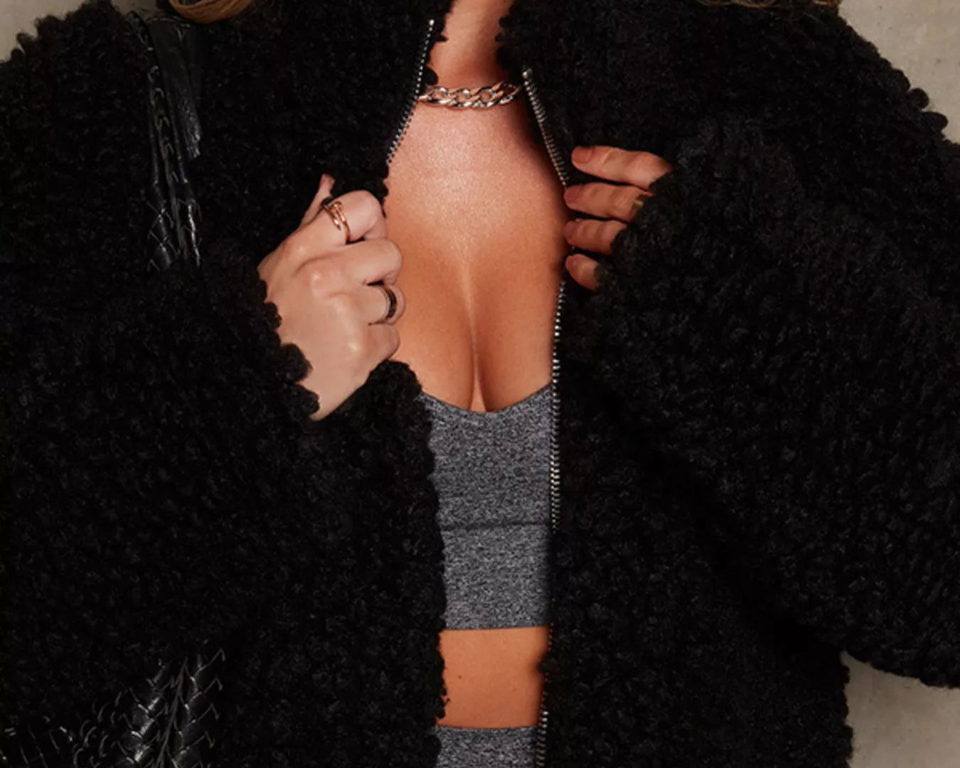 NEWYORKLISTED STYLE COLLECTION: Person wearing a black fluffy jacket with a neutral background