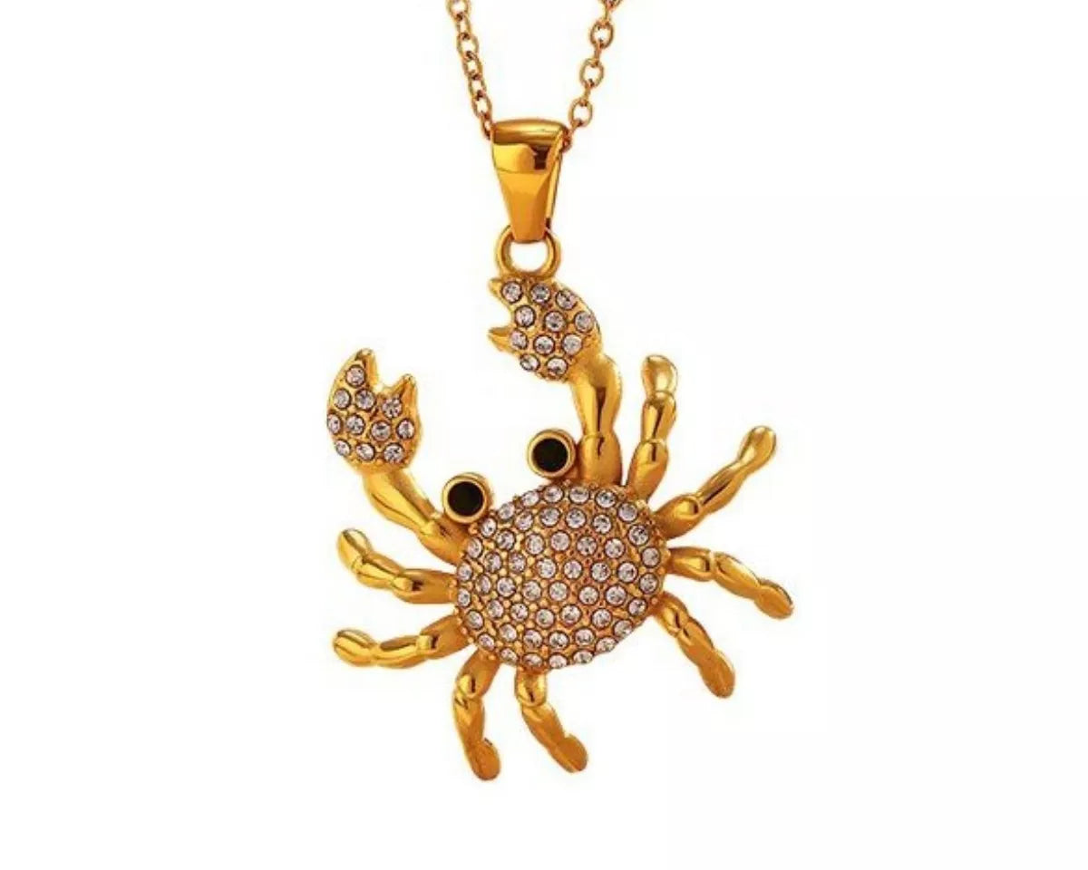 NYLD Glamour Collection by NEWYORKLISTED: Gold crab-shaped pendant necklace on a white background