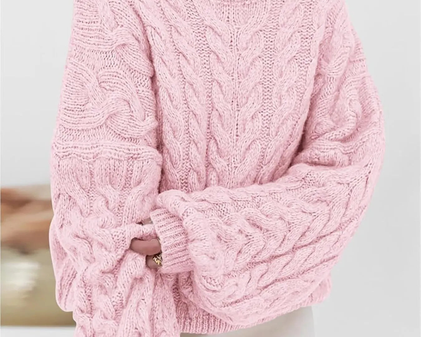 NEWYORKLISTED STYLE COLLECTION: Person wearing a pink cable knit sweater against a light background