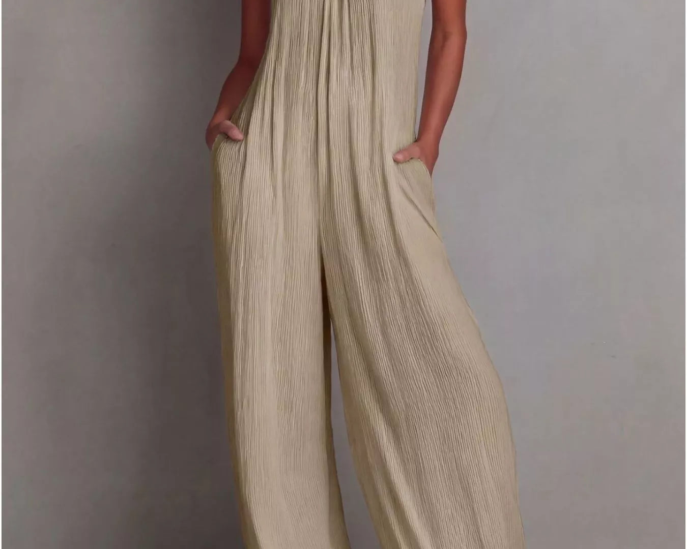 NEWYORKLISTED STYLE COLLECTION: Woman wearing a beige jumpsuit against a plain background
