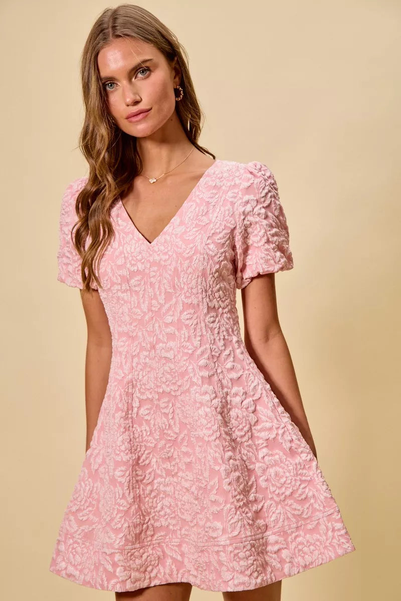 NEWYORKLISTED STYLE COLLECTION: Woman wearing a pink floral dress against a beige background
