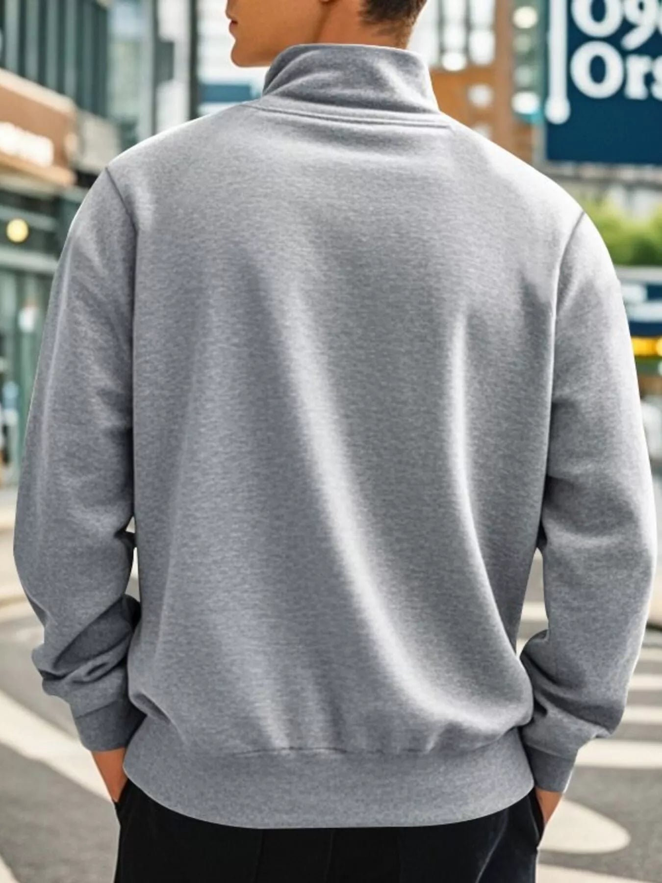NEWYORKLISTED ATLAS MEN'S COLLECTION: Person wearing a gray sweatshirt with a blurred urban background