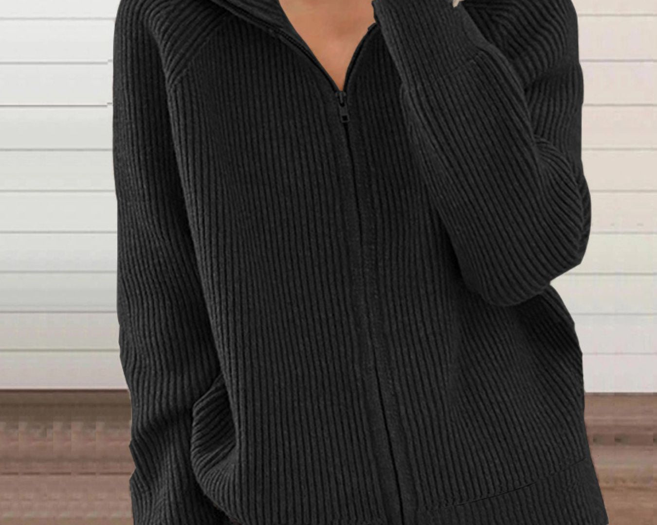 NEWYORKLISTED STYLE COLLECTION: Person wearing a black ribbed sweater against a neutral background