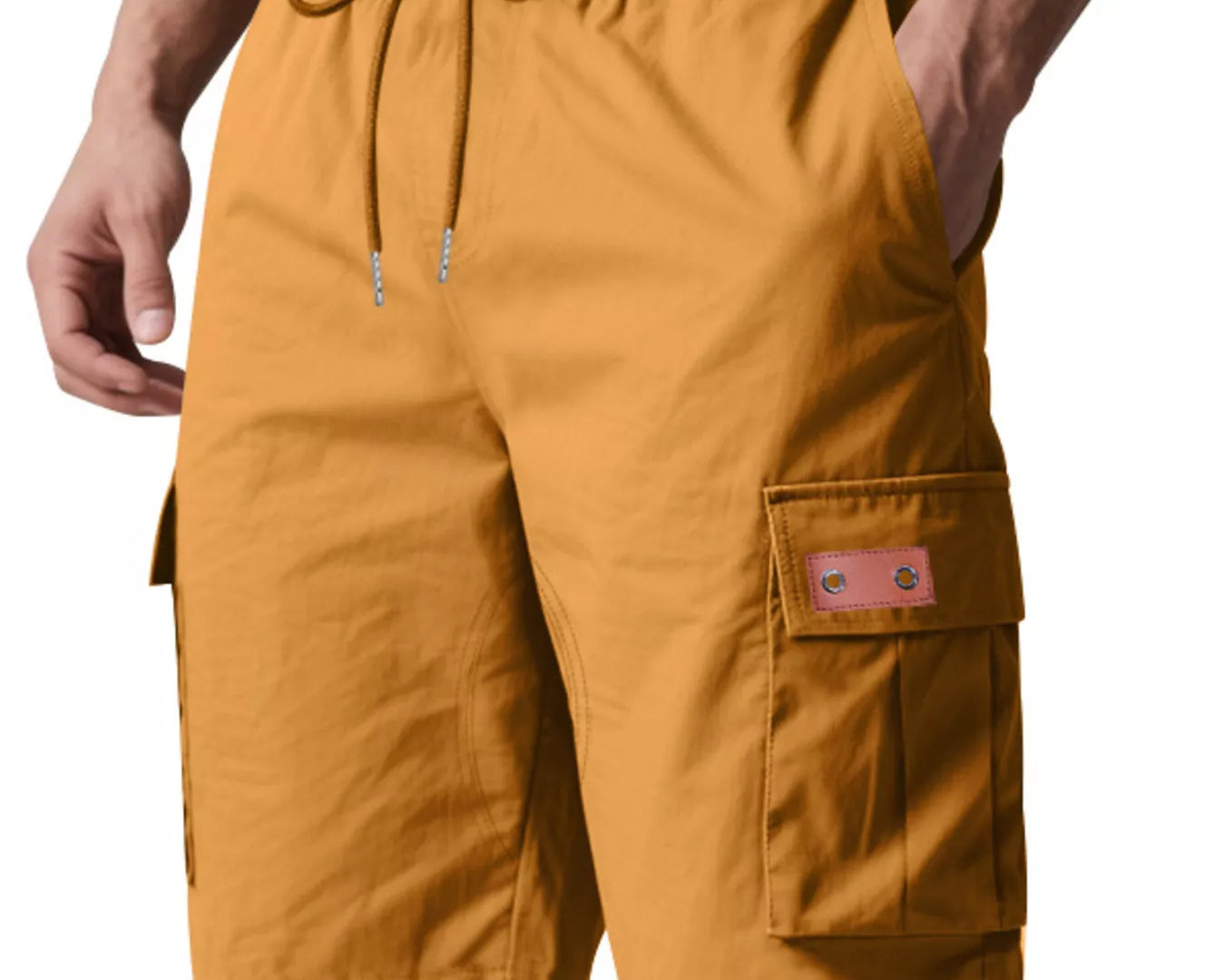 NEWYORKLISTED ATLAS MEN'S COLLECTION: Mustard yellow cargo shorts worn by a person on a white background