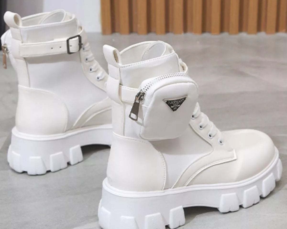 NEWYORKLISTED SHOE COLLECTION: White platform boots with zippers on a light gray floor.