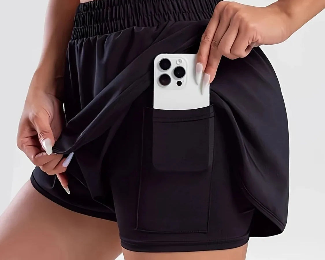 NEWYORKLISTED Activewear: Person wearing black shorts with a pocket holding a phone on a white background