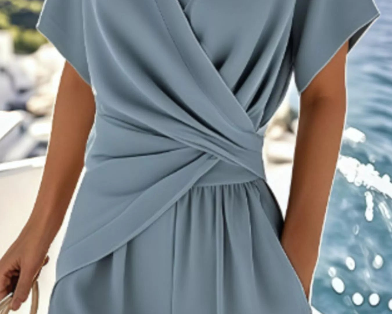 NEWYORKLISTED STYLE COLLECTION: Light blue jumpsuit worn by a person with a blurred background of water and boats.