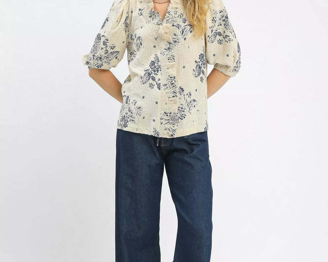 NEWYORKLISTED STYLE COLLECTION: Woman wearing a floral blouse and blue jeans on a white background