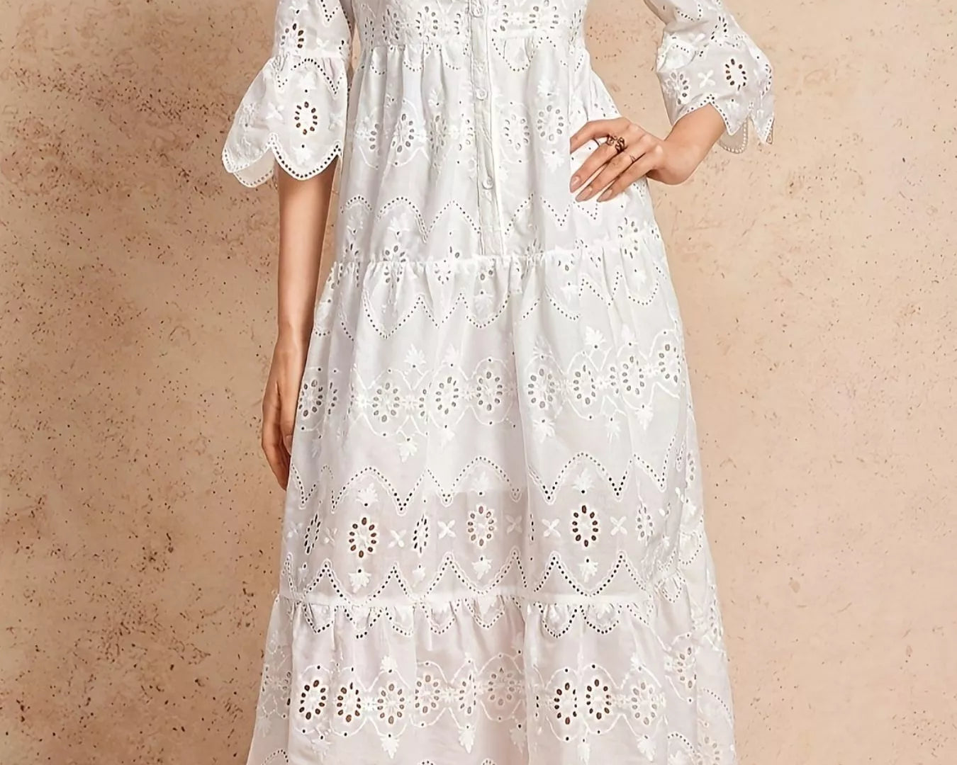 NEWYORKLISTED STYLE COLLECTION: White lace dress worn by a model on a beige background