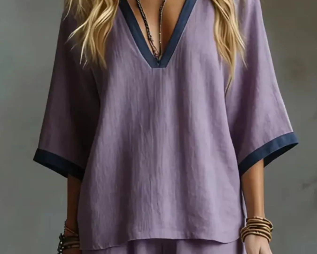 NEWYORKLISTED STYLE COLLECTION: Person wearing a purple outfit with a deep neckline against a neutral background