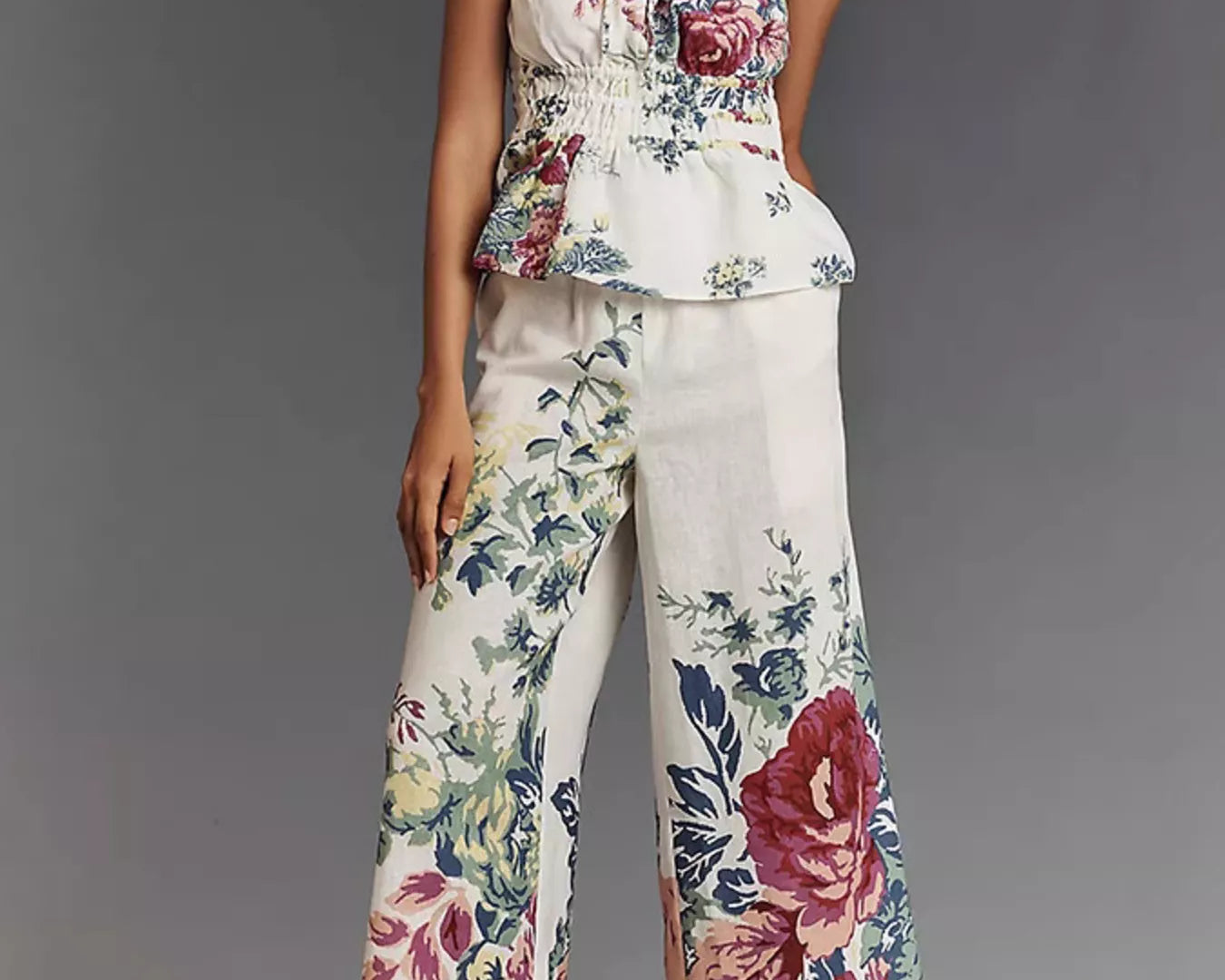 NEWYORKLISTED STYLE COLLECTION: Woman wearing a floral strapless top and wide-leg pants against a gray background