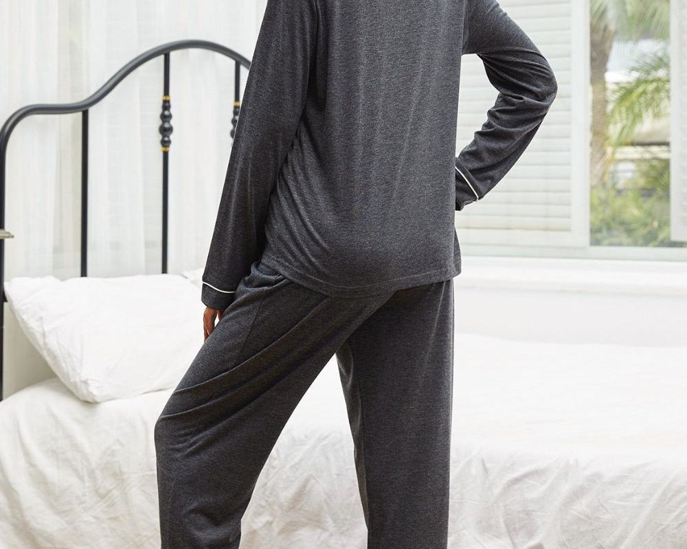 NEWYORKLISTED Intimate Apparel: Woman wearing gray pajamas standing in a bedroom.
