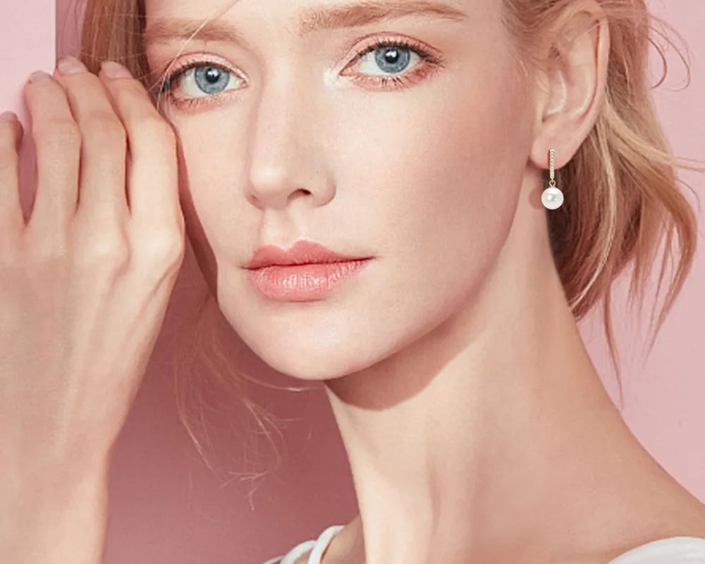 NYLD GLAMOUR COLLECTION by NEWYORKLISTED: Woman wearing a white tank top with a soft pink background