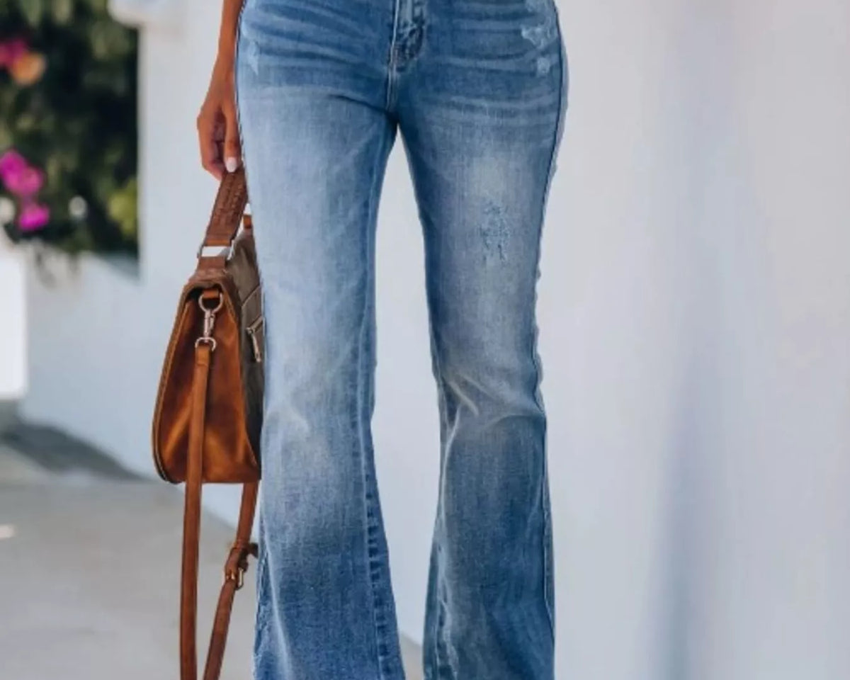 NEWYORKLISTED STYLE COLLECTION: Model is wearing blue pair of denim jeans which combines a flared silhouette with distressed detailing for a look that feels relaxed yet thoughtfully styled.