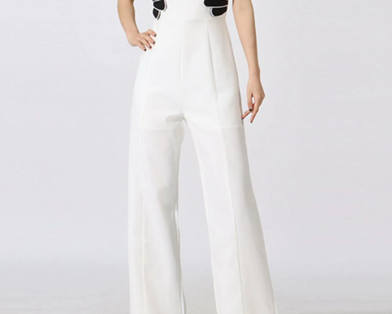NEWYORKLISTED STYLE COLLECTION: White jumpsuit with black decorative elements on a white background