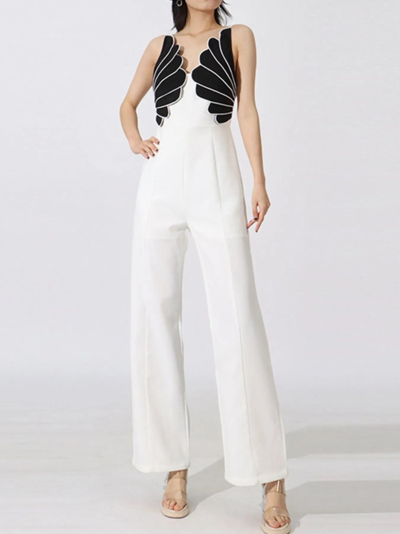 NEWYORKLISTED STYLE COLLECTION: White jumpsuit with black decorative elements on a white background