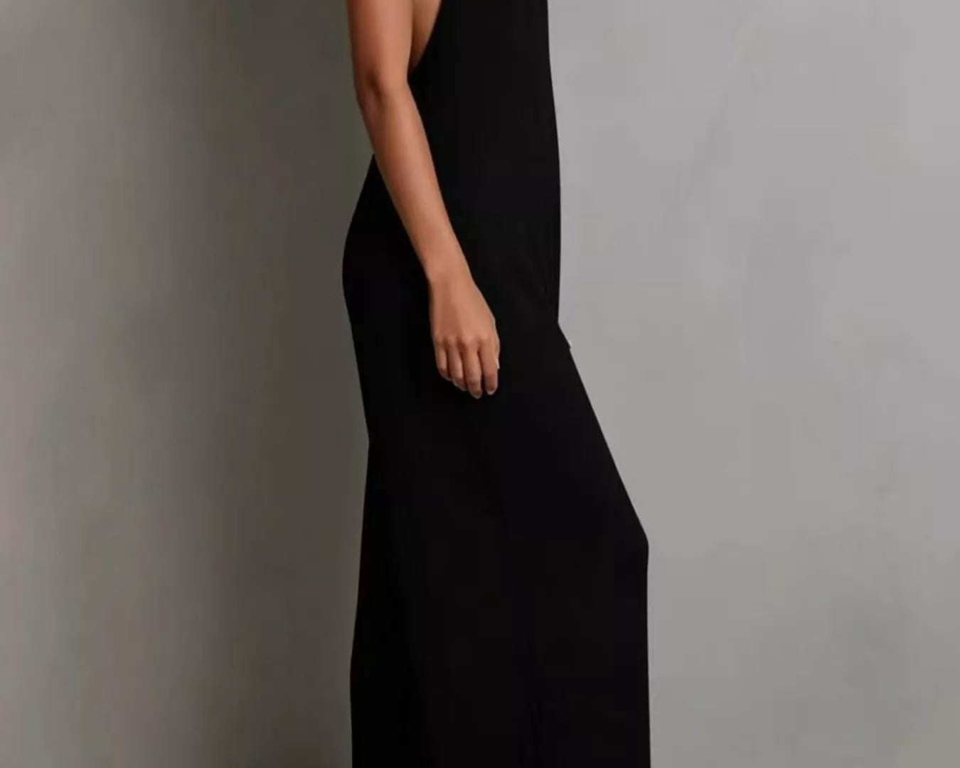 NEWYORKLISTED STYLE COLLECTION: Person wearing a black halter neck dress against a plain background