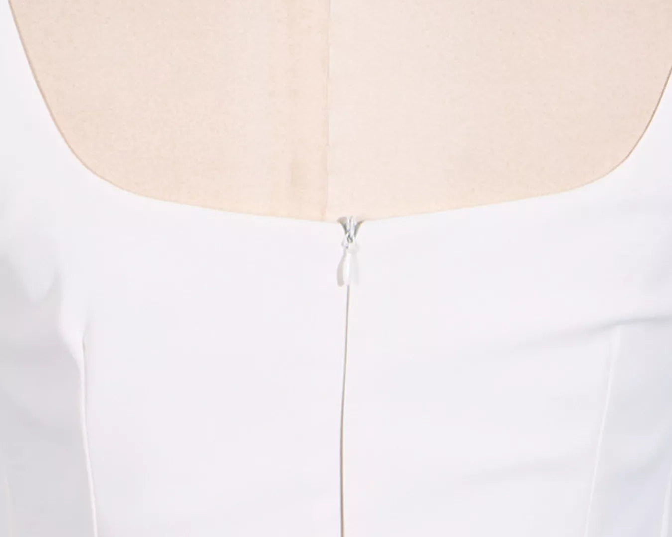 NEWYORKLISTED STYLE COLLECTION: White dress on a mannequin with a close-up of the back neckline.