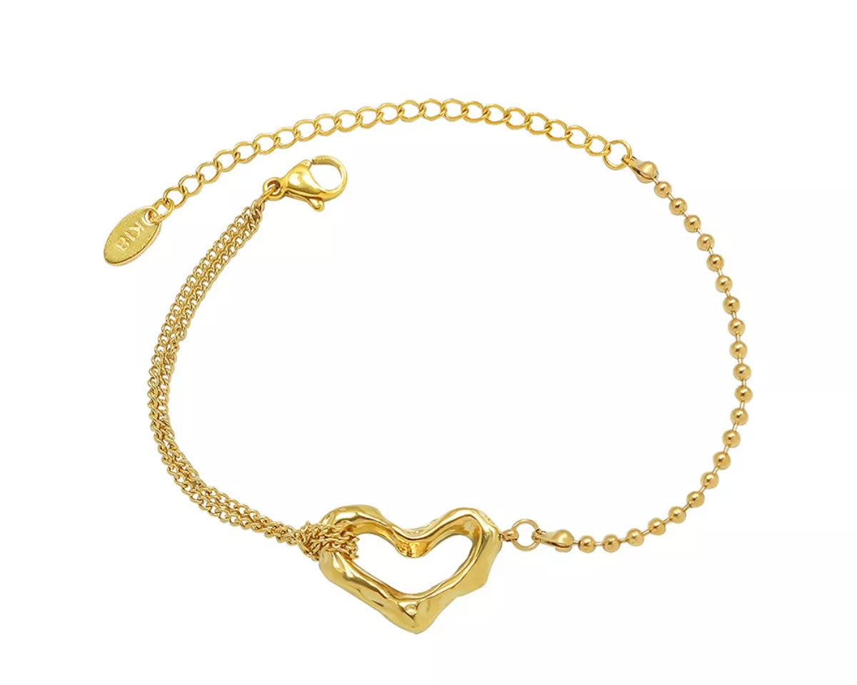 NYLD Glamour Collection by NEWYORKLISTED: Gold bracelet with a heart-shaped clasp on a white background