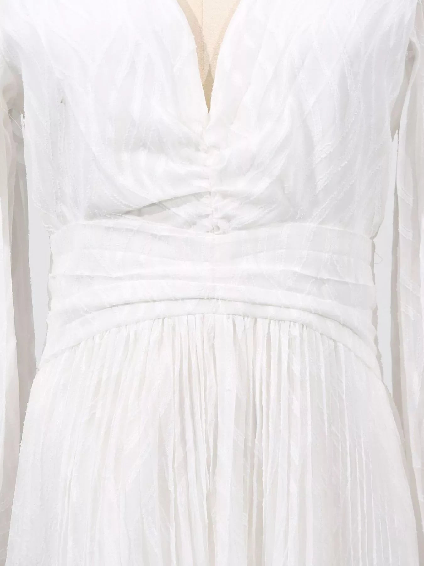 NEWYORKLISTED STYLE COLLECTION: Close-up of a white dress with a textured fabric and pleated design.