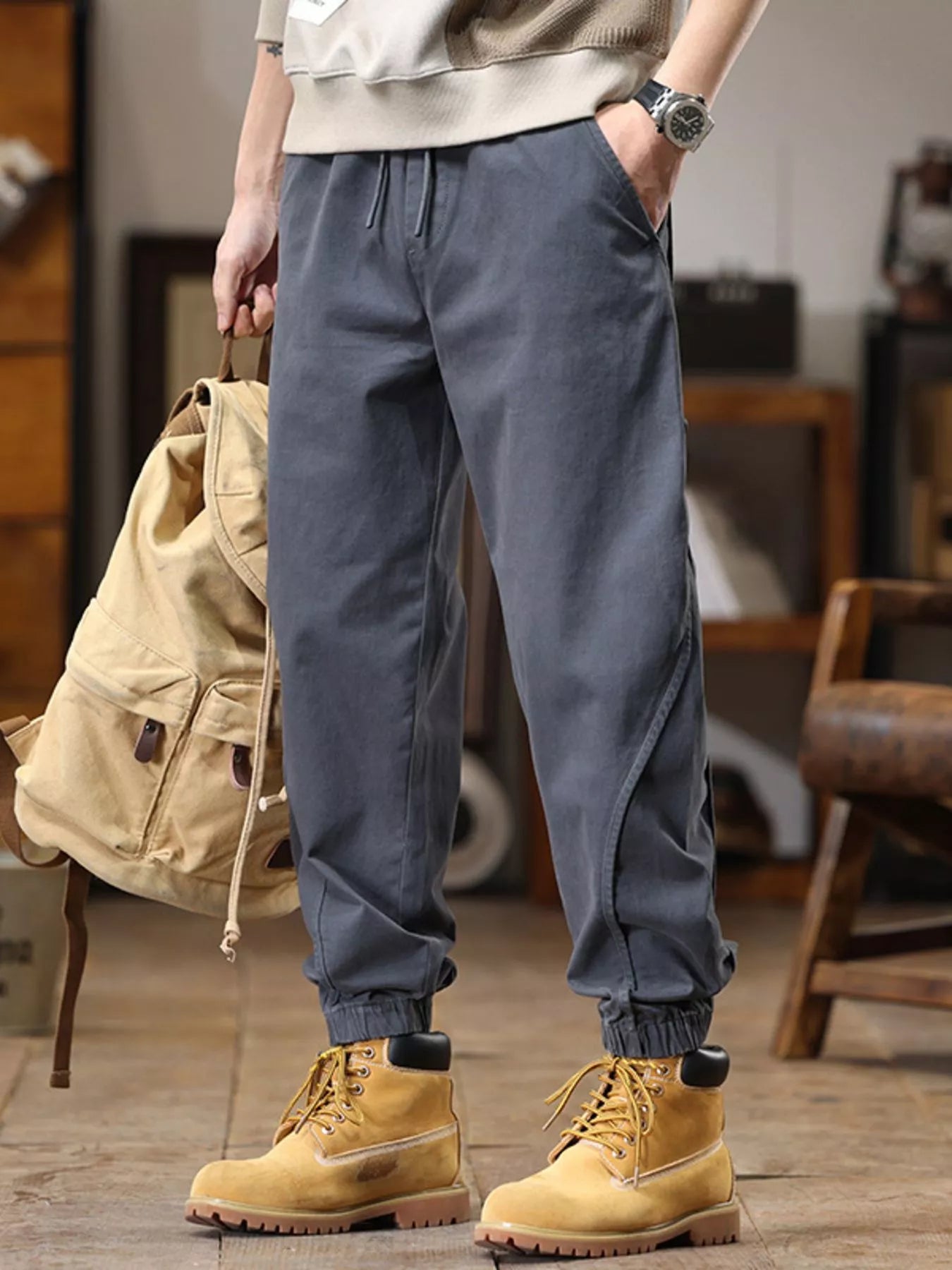 NEWYORKLISTED ATLAS MEN'S COLLECTION: Person wearing gray jogger pants and yellow boots in an indoor setting.
