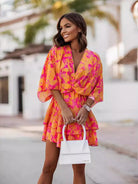 NEWYORKLISTED STYLE COLLECTION: Woman wearing a colorful dress with a blurred outdoor background