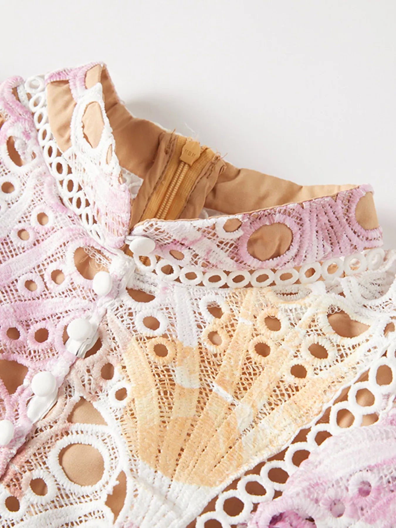 NEWYORKLISTED STYLE COLLECTION: Close-up of lace lingerie with pink and beige tones on a white background
