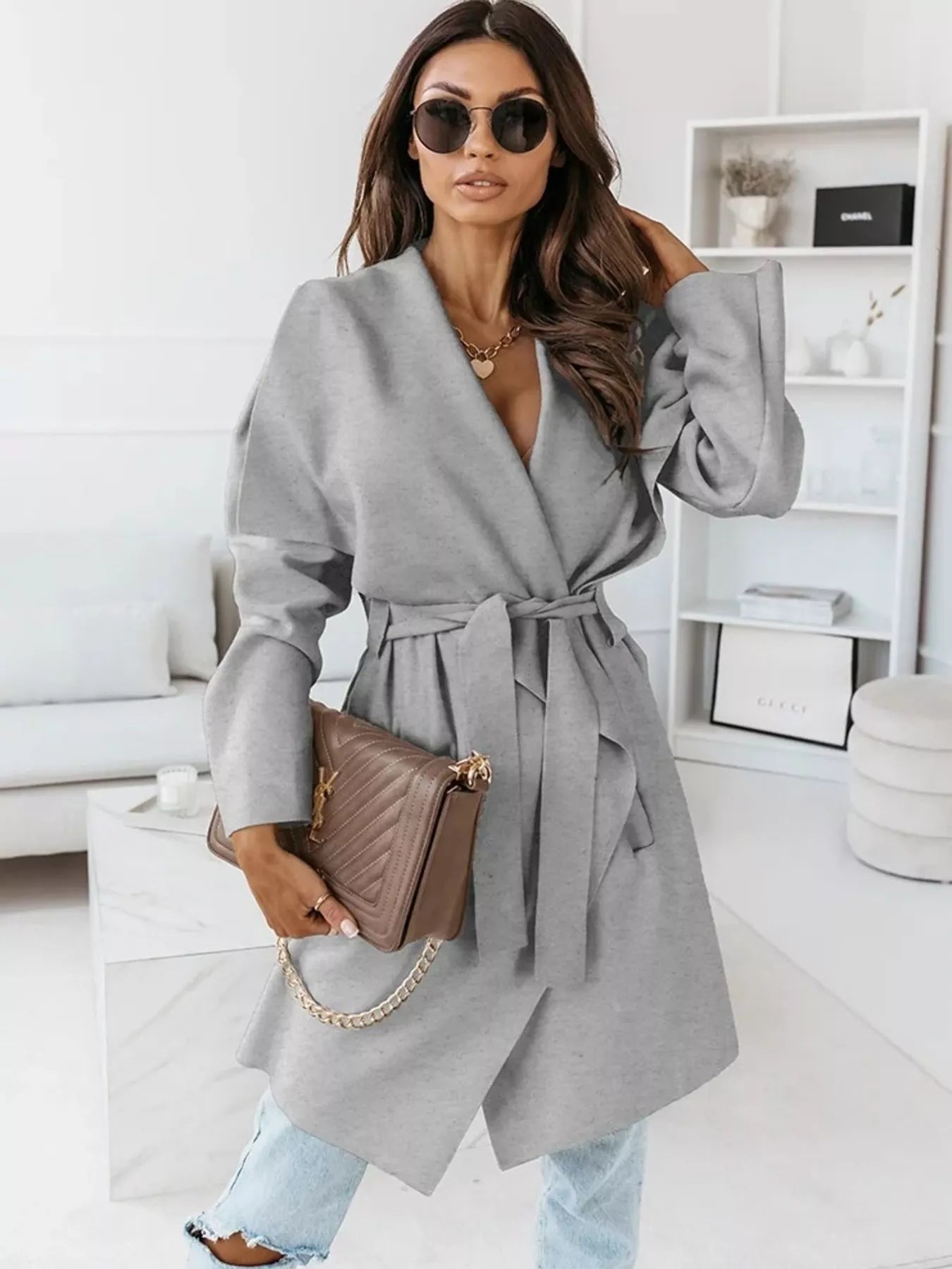NEWYORKLISTED STYLE COLLECTION: Woman wearing a gray coat in a modern living room