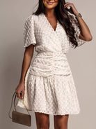 NEWYORKLISTED STYLE COLLECTION: Woman wearing a white lace dress against a neutral background