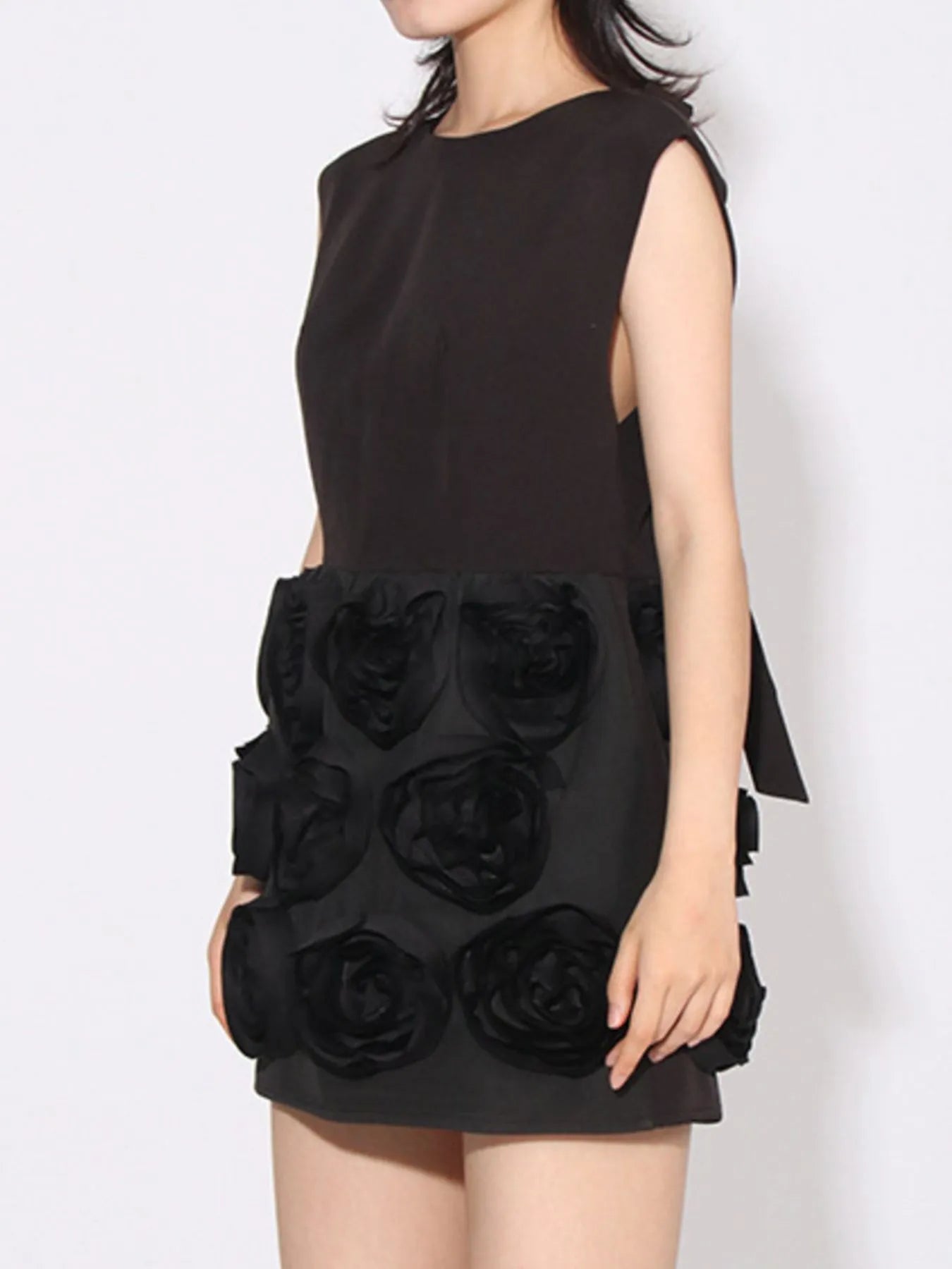 NEWYORKLISTED RUNWAY STYLE: Black sleeveless dress with floral details on a white background