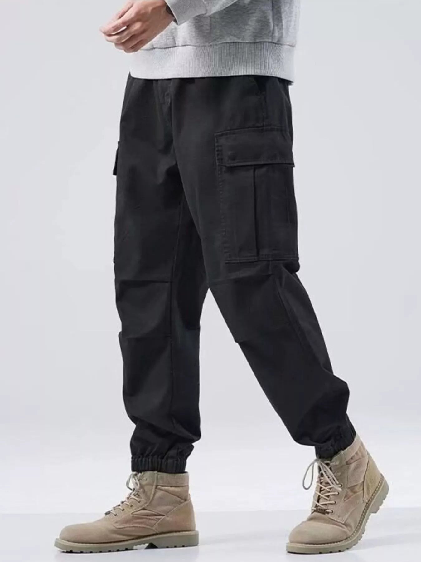 NEWYORKLISTED ATLAS MEN'S COLLECTION: Person wearing black cargo pants and beige boots on a white background