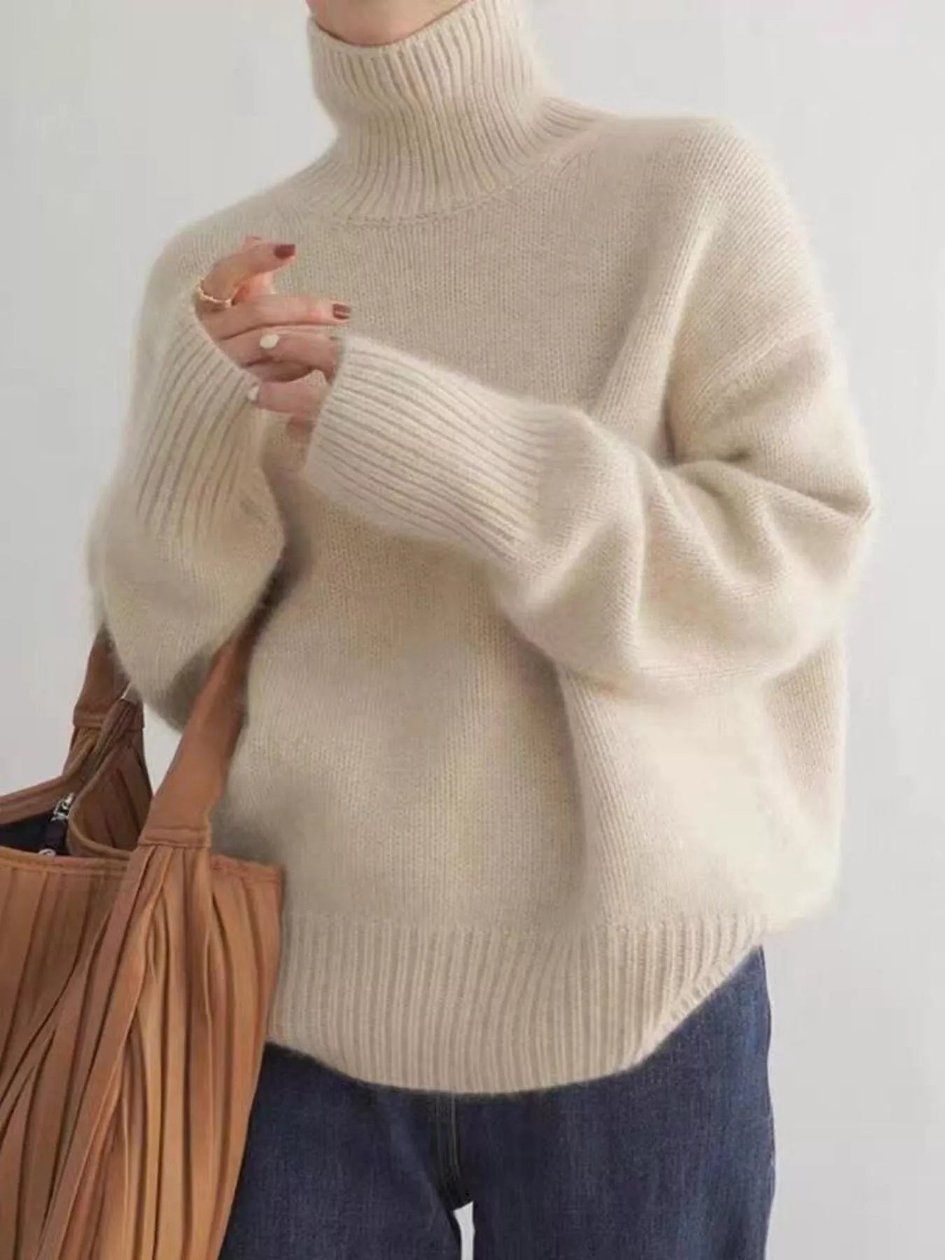 Person wearing a beige sweater with a plain background on NEWYORKLISTED.COM