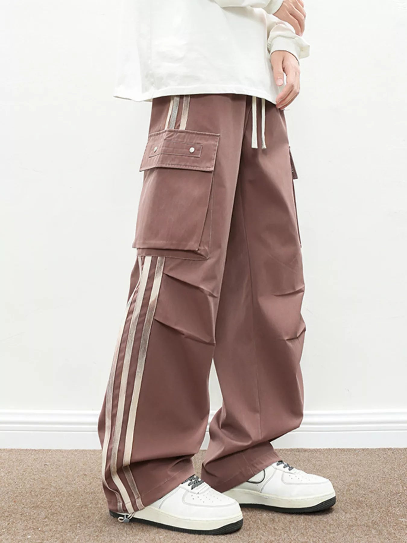 NEWYORKLISTED ATLAS MEN's COLLECTION: Brown cargo pants with white stripes worn by a person on a plain background