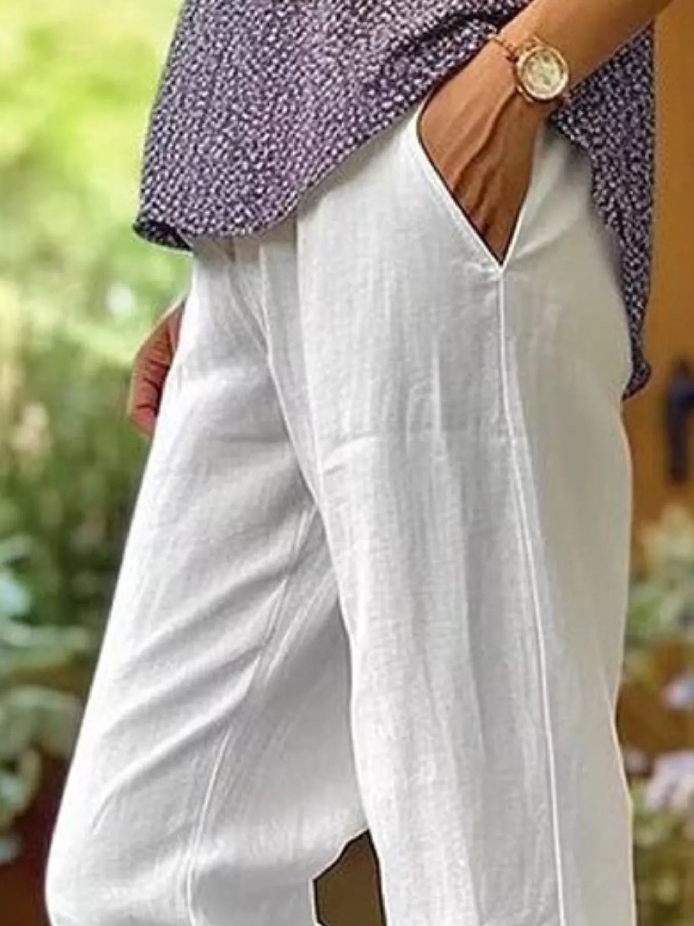NEWYORKLISTED STYLE COLLECTION: White wide-leg linen pants with side pockets, worn by a model in an outdoor setting.
