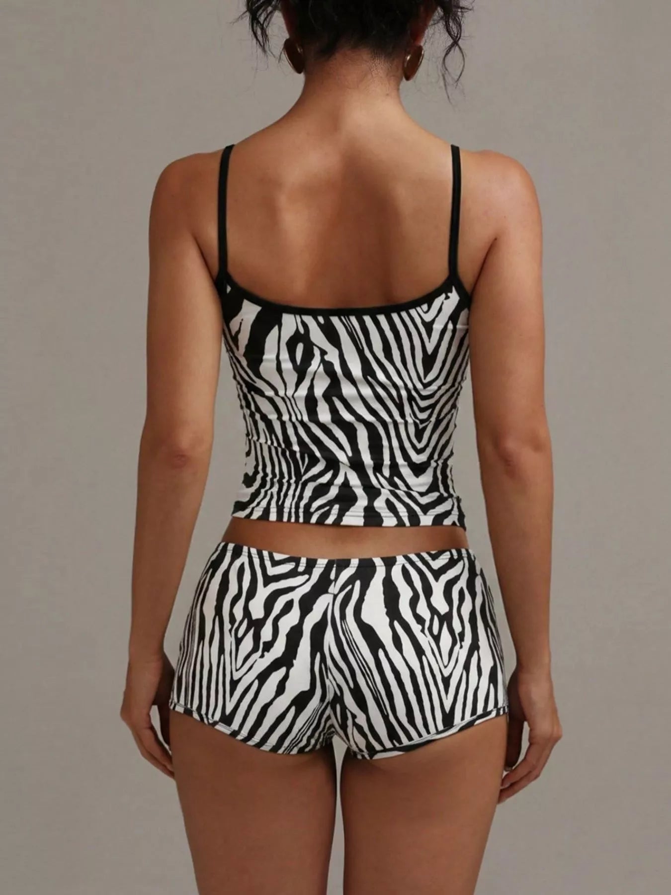 NEWYORKLISTED INTIMATE APPAREL COLLECTION: Person wearing a zebra print two-piece set against a neutral background