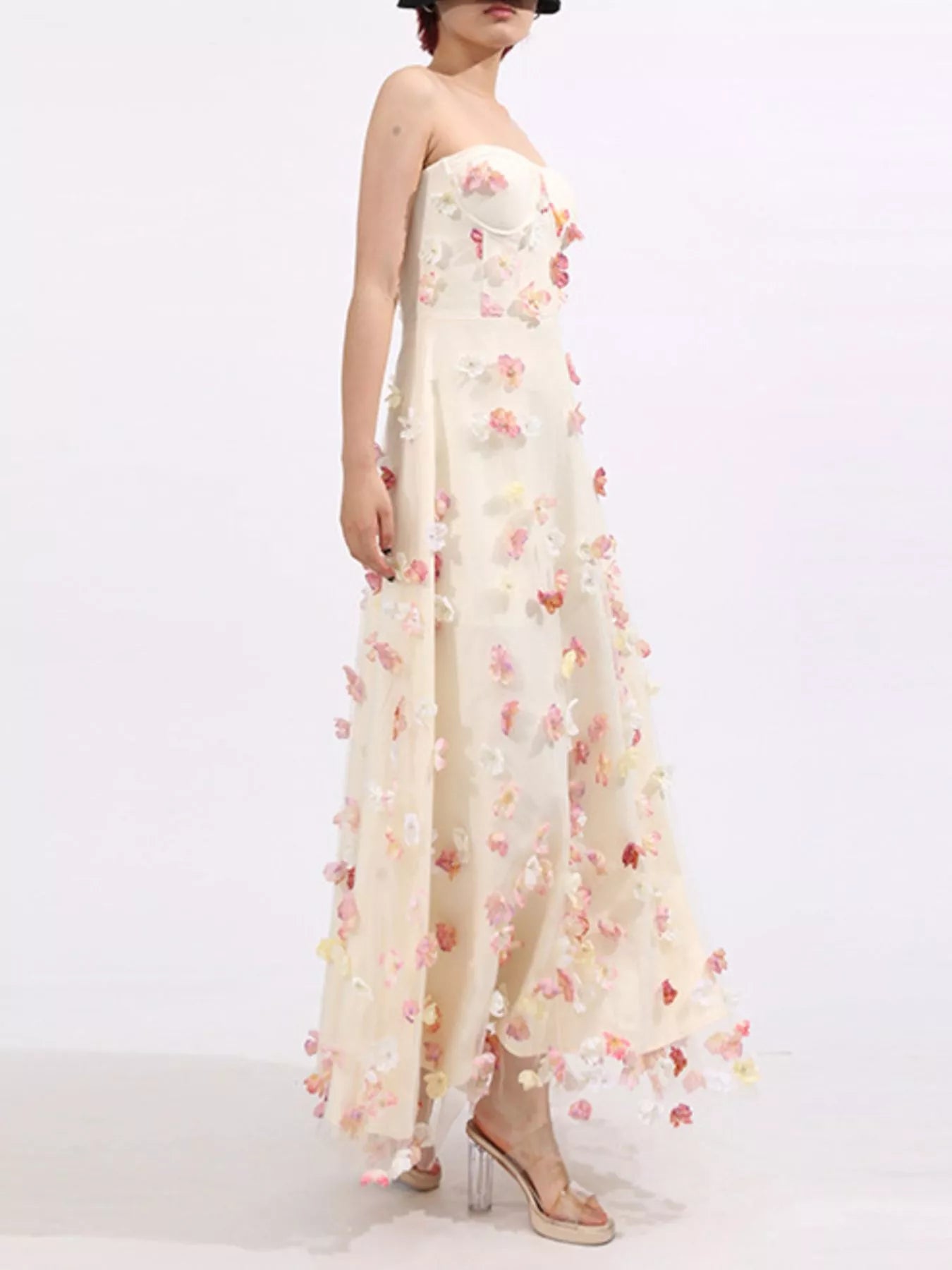 NEWYORKLISTED STYLE COLLECTION: Woman wearing a strapless floral gown on a white background