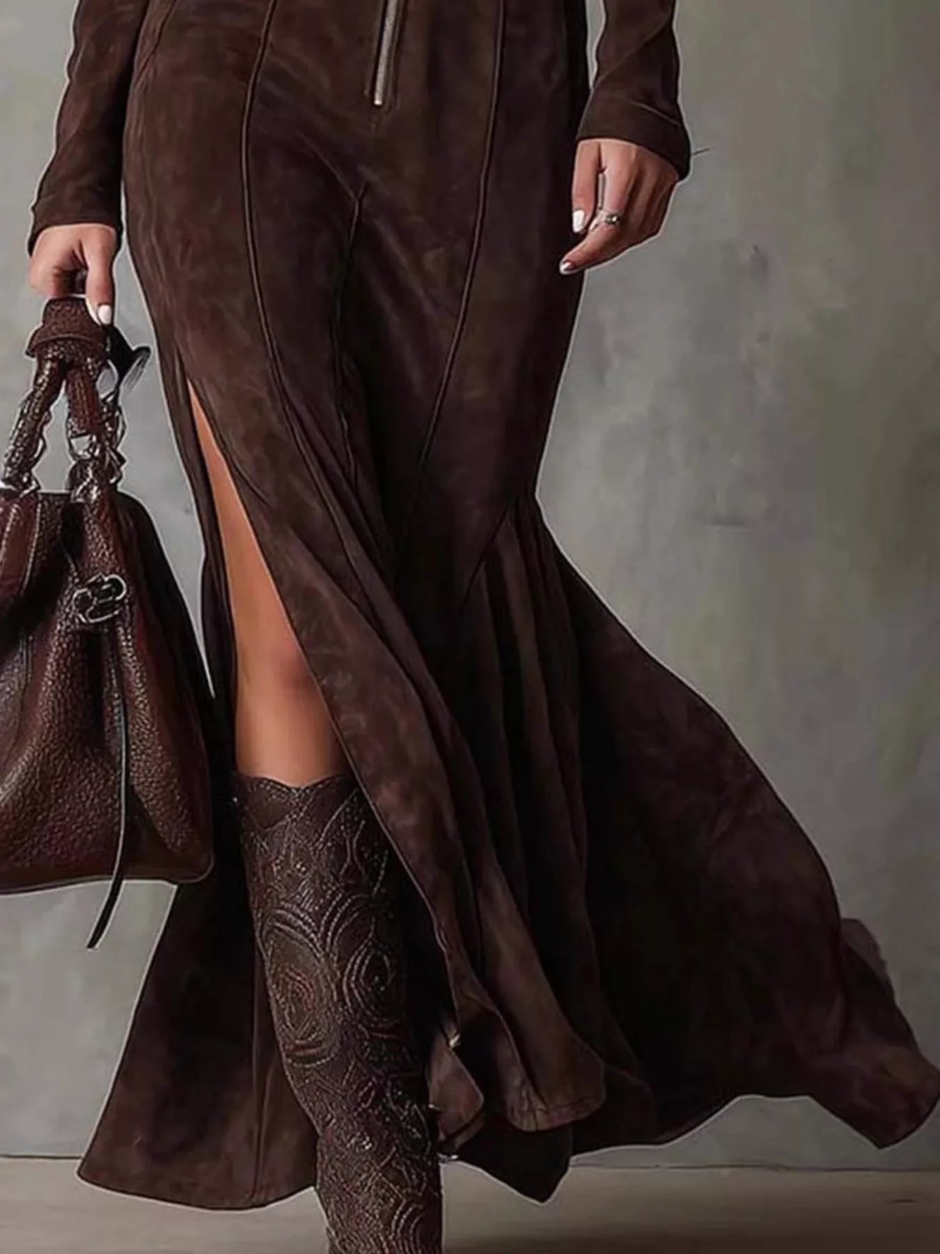 NEWYORKLISTED STYLE COLLECTION: Person wearing a brown suede dress with a slit, holding a matching handbag against a neutral background.