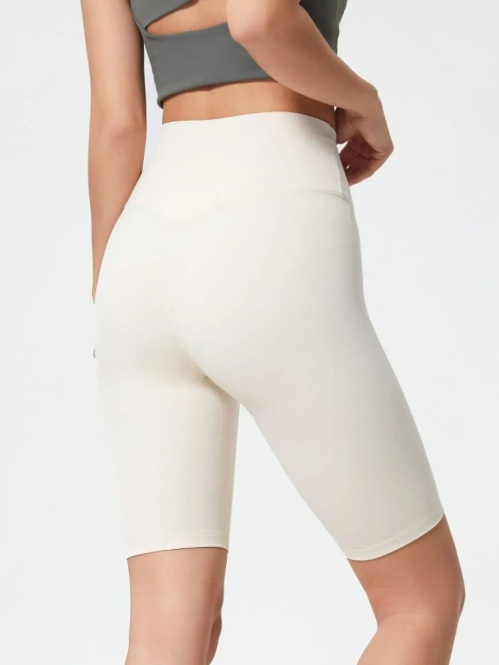 White athletic shorts worn by a person on a light gray background