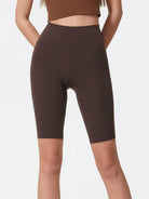 NEWYORKLISTED ACTIVEWEAR COLLECTION: Brown high-waisted shorts worn by a person on a white background