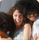 NEWYORKLISTED Cosmetic Collection: Natural Curl Care products, three women smiling on a pink background